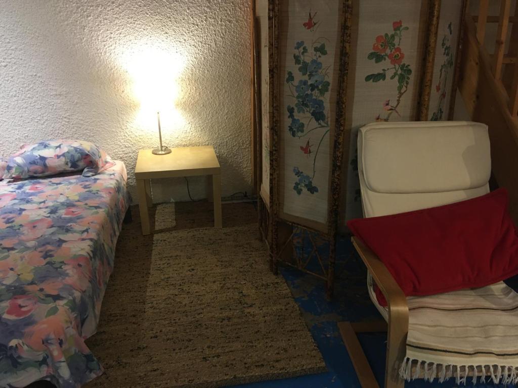 Cette chambre comprend un lit, une table et une chaise. dans l&#39;établissement Lovely Cevenol village house, à Saint-Laurent-le-Minier