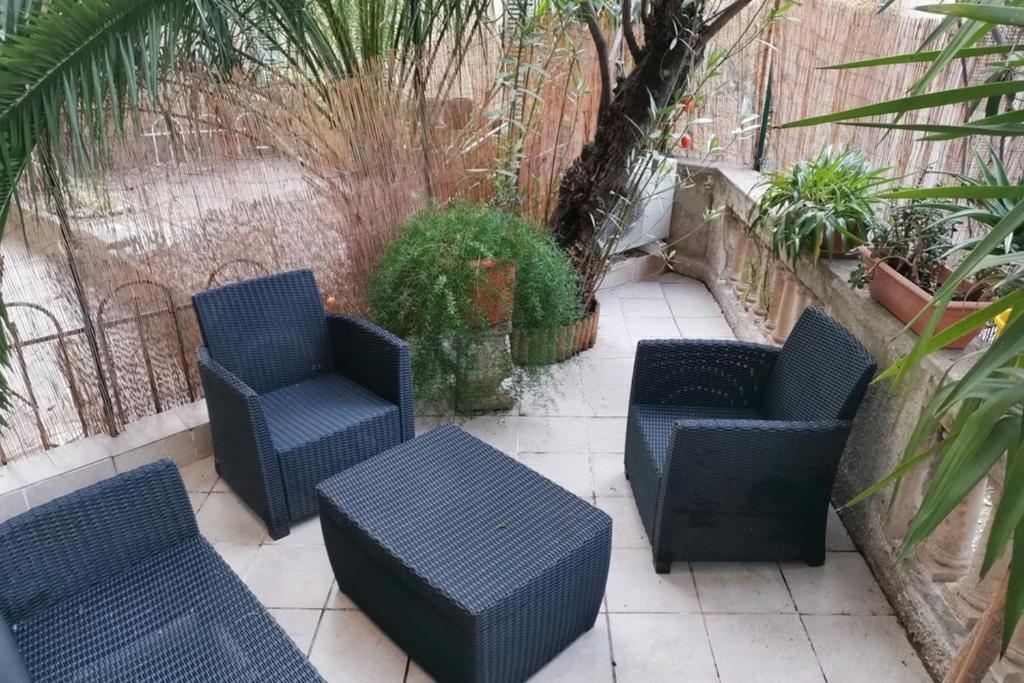 un groupe de chaises et de tables sur une terrasse dans l'établissement Large studio 37 m with terrace, à Nice