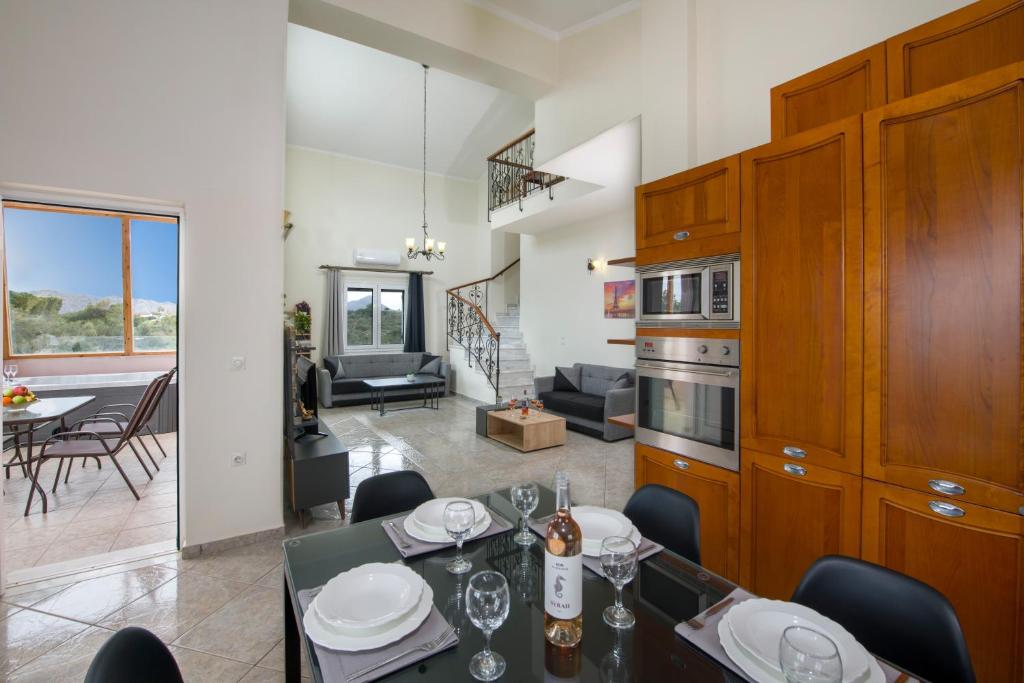 cocina y sala de estar con mesa y sillas en Ifigeneia's Luxury Resort with Private Hot Tub, en Kalathas