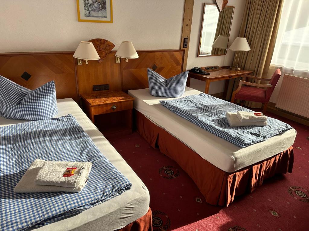 TettauにあるHotel Söllnerのベッド2台とデスクが備わるホテルルームです。