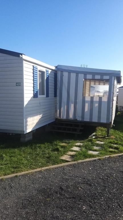 a white caravan sitting on the side of the road at aventura 6 personnes in Litteau