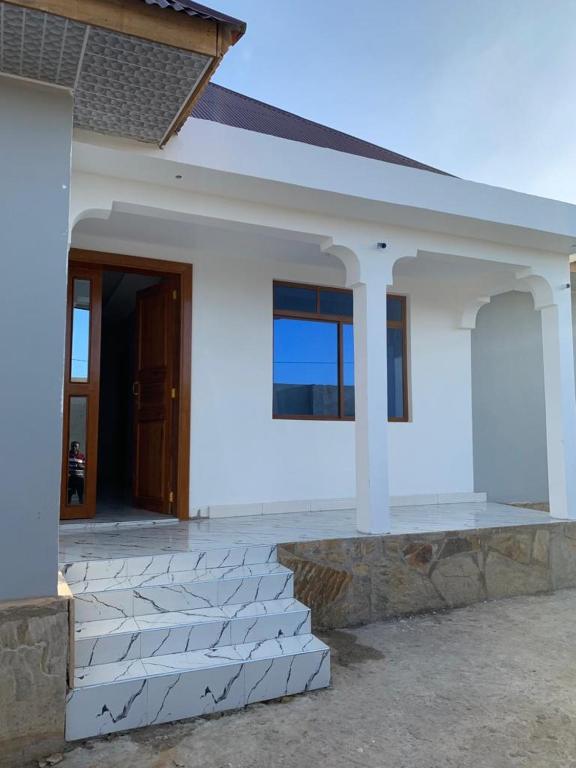 ein weißes Haus mit einer Treppe davor in der Unterkunft Nungwi holiday apartments in Nungwi
