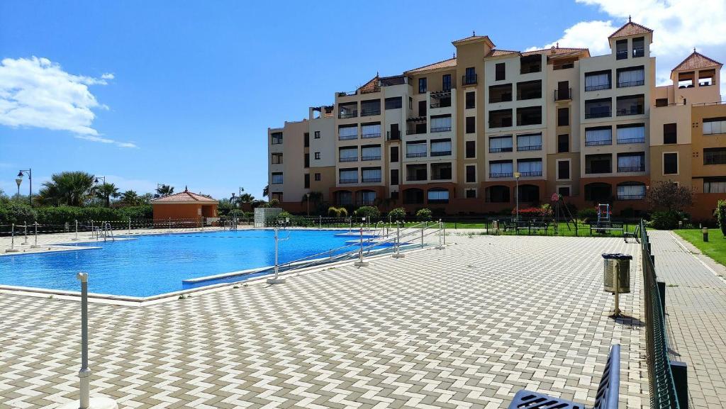 een groot zwembad voor een gebouw bij Apartamento Los Pelícanos in Isla Canela