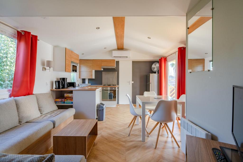 uma sala de estar e cozinha com um sofá e uma mesa em Mobil home Cécile em Fréjus