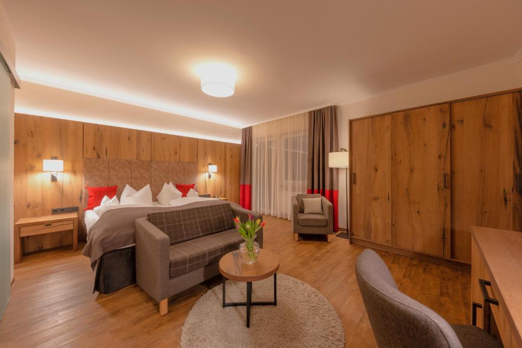 ツヴィーゼルにあるHotel Bavariaのベッド、ソファ、テーブルが備わるホテルルームです。