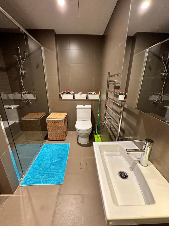 ein Badezimmer mit einem weißen Waschbecken und einem WC in der Unterkunft Best location apartment in Olympic park in Sydney