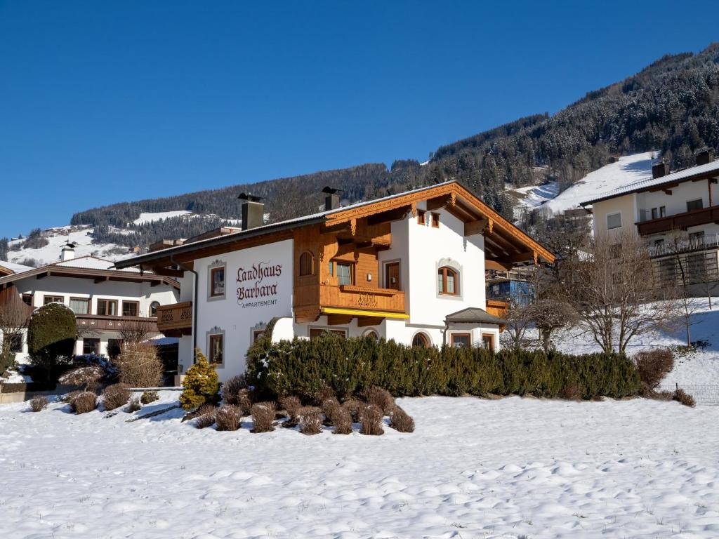 um edifício na neve em frente a uma montanha em Landhaus Barbara em Ramsau im Zillertal