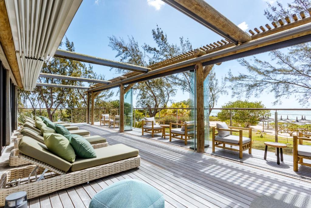 a patio with a couch and chairs on a deck at Lagoon Attitude (Adults Only) in Cap Malheureux