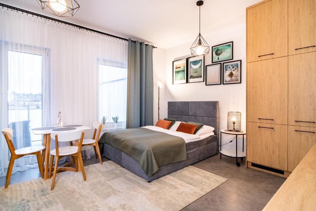 Schlafzimmer mit einem Bett, einem Tisch und Stühlen in der Unterkunft ApartamentySnu, Jagielloński Komfort, Centrum in Radom