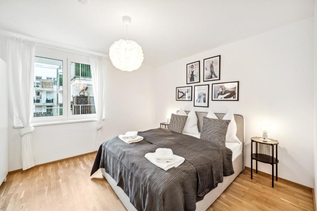 ein weißes Schlafzimmer mit einem Bett und einem Fenster in der Unterkunft Arbio I Design Apartments in Favoriten Vienna in Wien