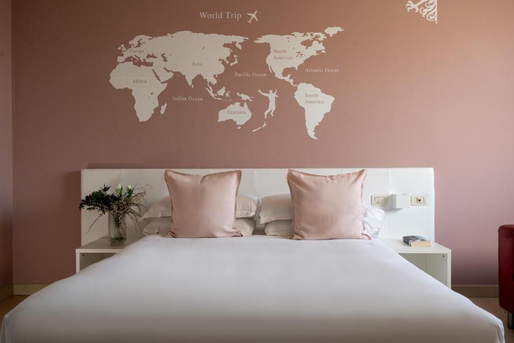 a bedroom with a white bed with a world map on the wall at Castello D'Argile Hotel in Castello dʼArgile