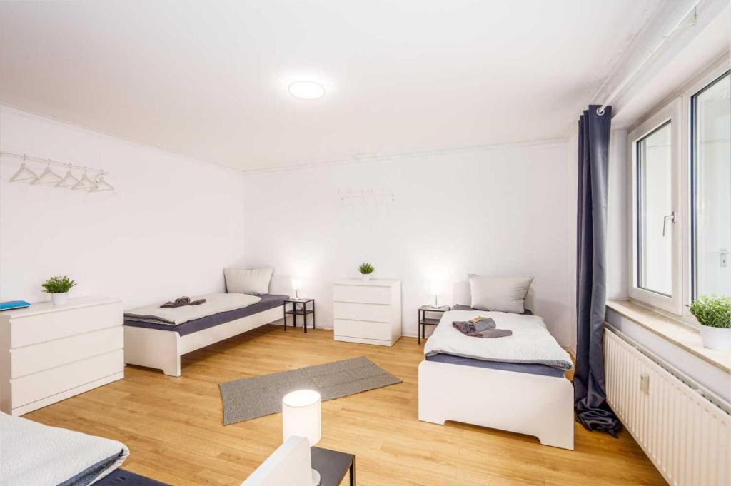 a white room with two beds and a window at Modern Apartment near Bottrop in Gladbeck