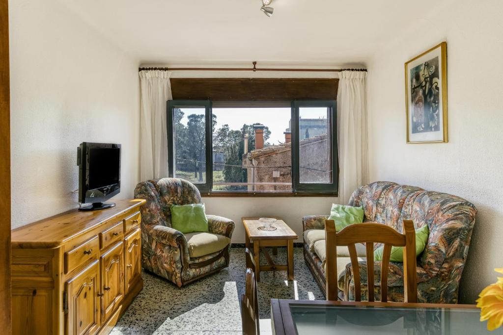 salon z telewizorem, krzesłami i oknem w obiekcie Can Picola w mieście Capmany
