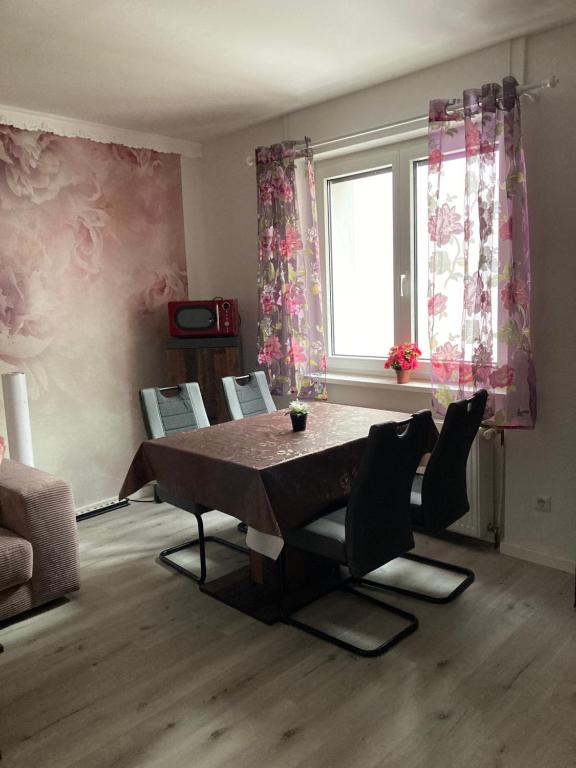 uma sala de estar com uma mesa e cadeiras e uma janela em Ferienwohnung Sonne em Landstuhl