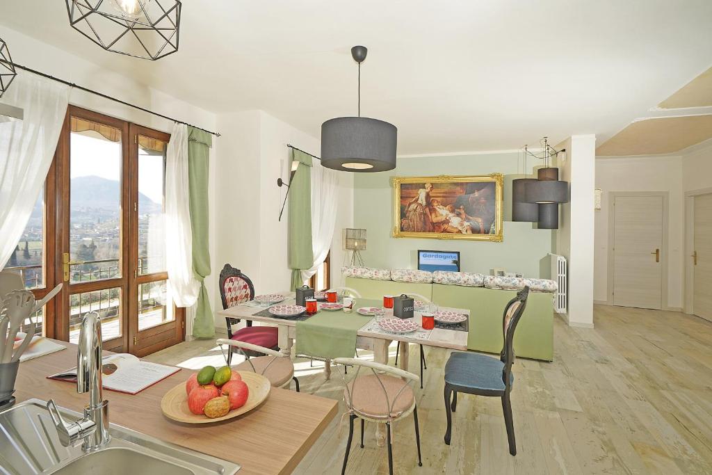 Il comprend une cuisine et un salon avec une table et des chaises. dans l'établissement Le Fontane Lux - Gardagate, à Roe