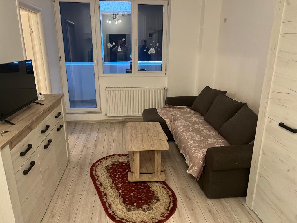 a living room with a couch and a table at Apartament Militari Residence in Roşu