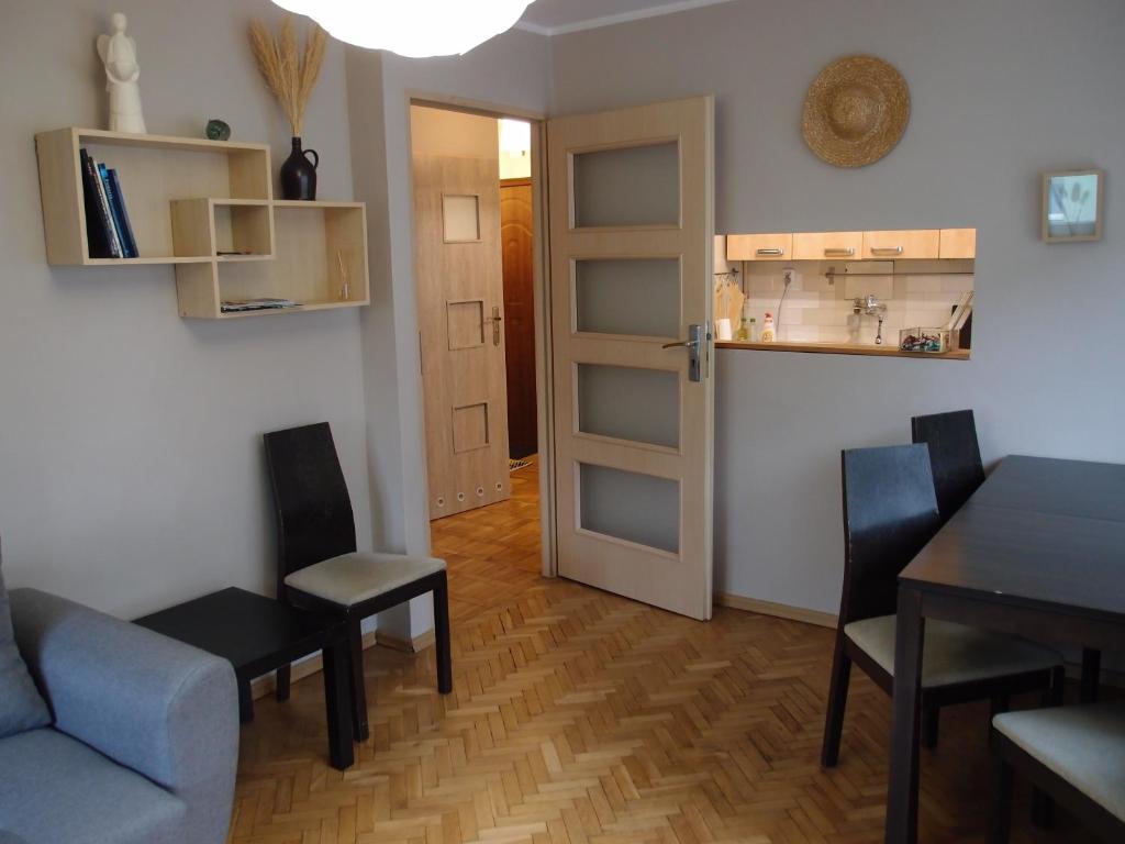uma sala de estar com uma mesa e cadeiras e uma porta em Sunny Seven em Gdynia