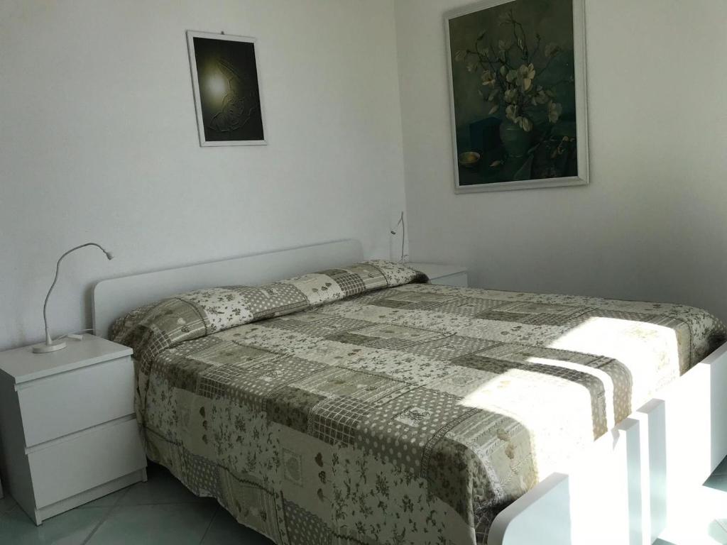 1 dormitorio con 1 cama y una foto en la pared en L' Ulivo Villa Nunzia, en Isquia