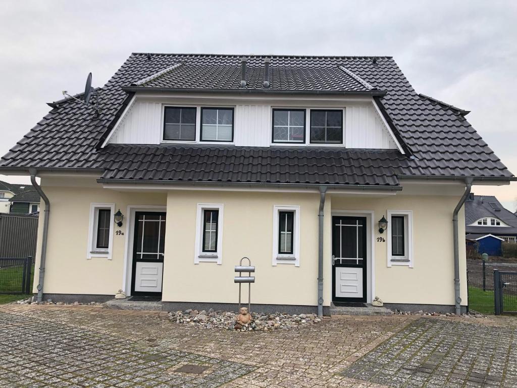 a white house with a black roof at Strandstr_ in Zingst