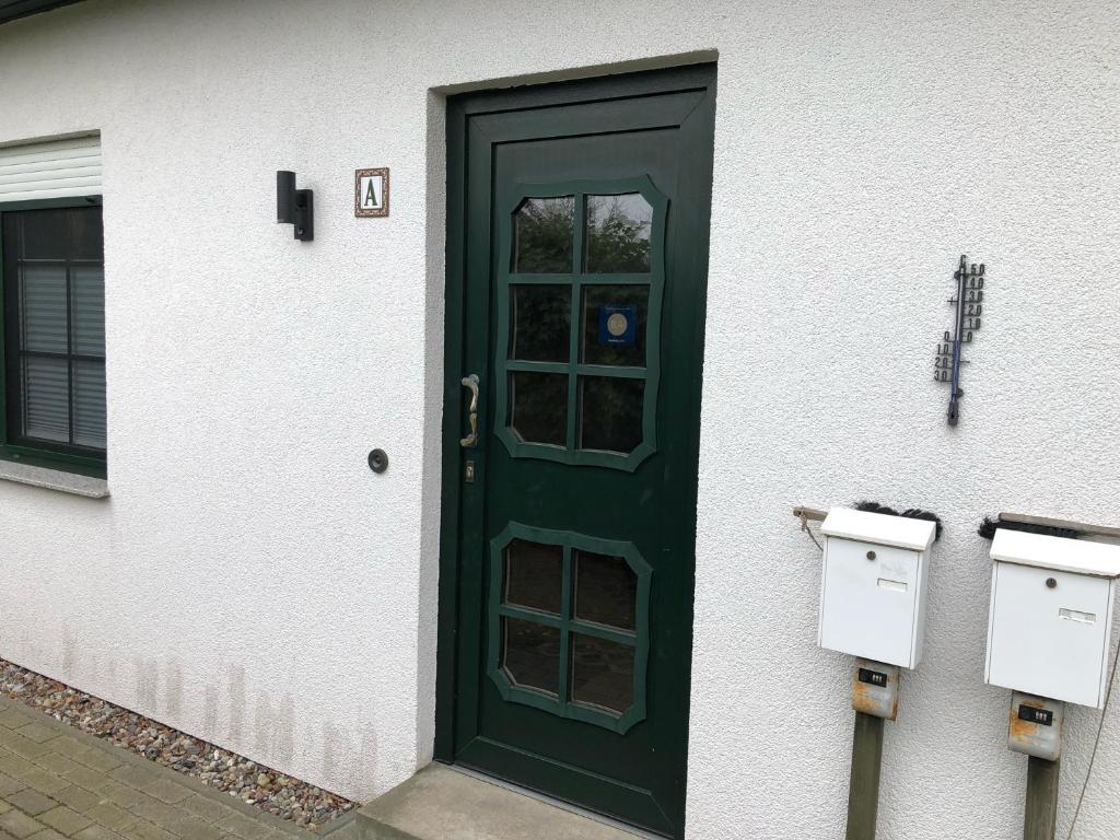 a green door on the side of a building at Seestr 75 a Haus A links in Zingst