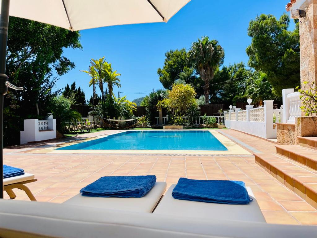 a villa with a swimming pool with two blue towels at Villa con piscina gigante in Sant Francesc de s'Estany