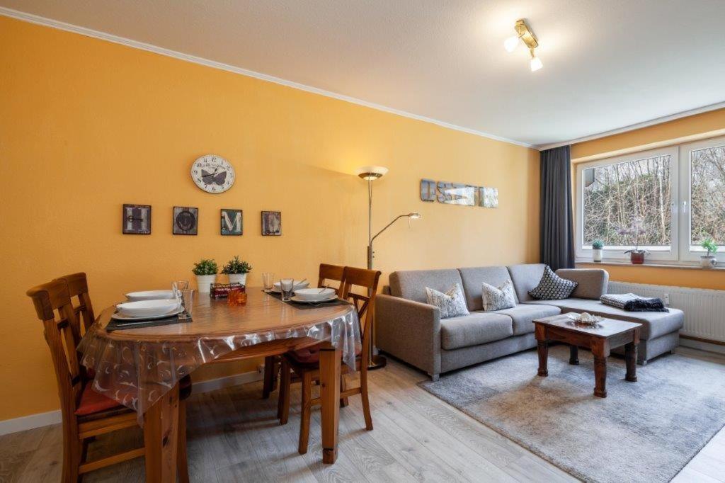 - un salon avec une table et un canapé dans l'établissement Haus Meeresgruß, Appartement Flair, à Grömitz