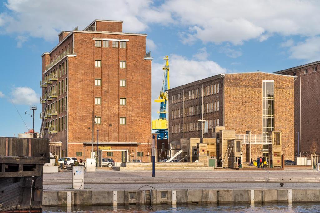 een groot bakstenen gebouw naast een waterlichaam bij Ferienapartments am Krusespeicher Ferienapartments am Krusespeicher 1-05 in Wismar