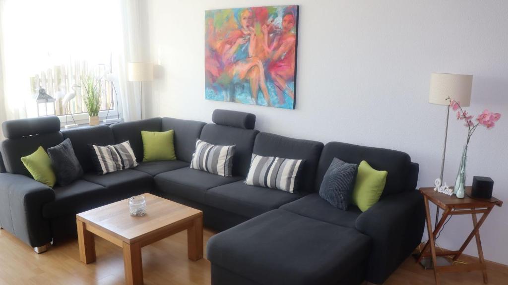 uma sala de estar com um sofá azul e uma mesa em Ferienwohnung Deichblick em Dornumersiel