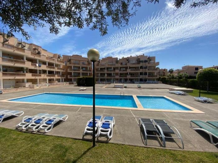 basen z leżakami obok budynku w obiekcie Apartamento Rosa w mieście Cala Bona