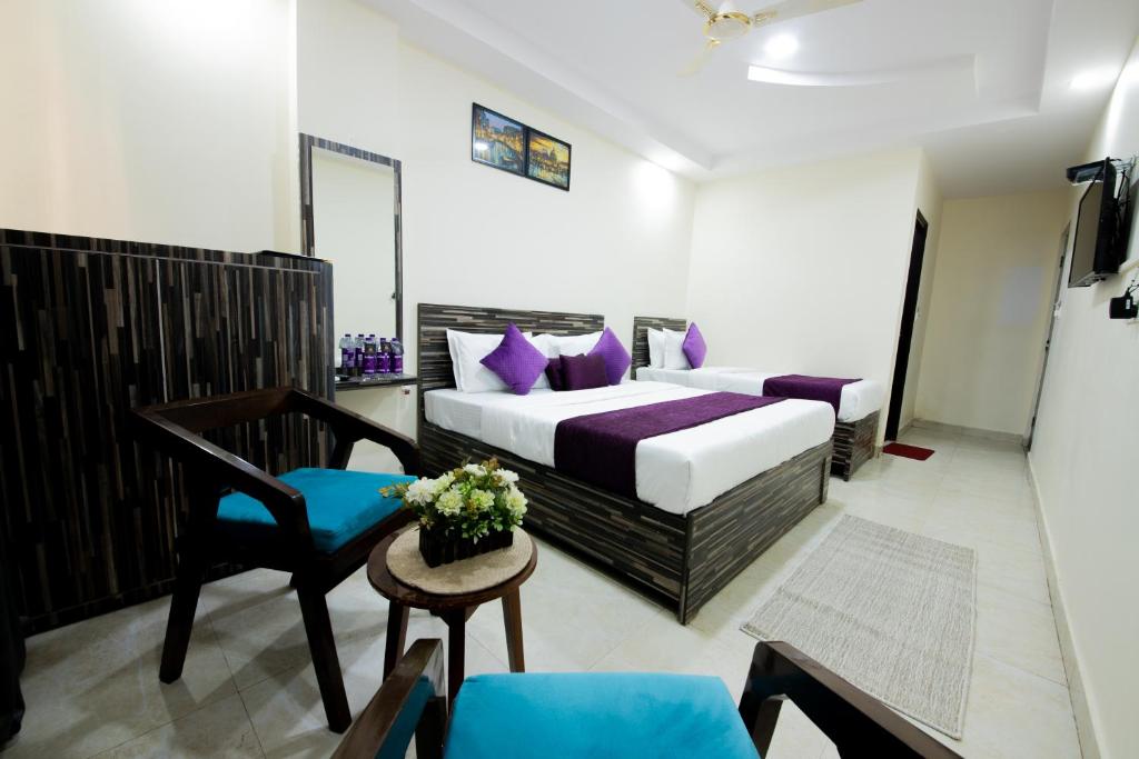 a hotel room with a bed and a chair at Umra Grace - Hotel in Haridwar By Perfect Stayz in Haridwār