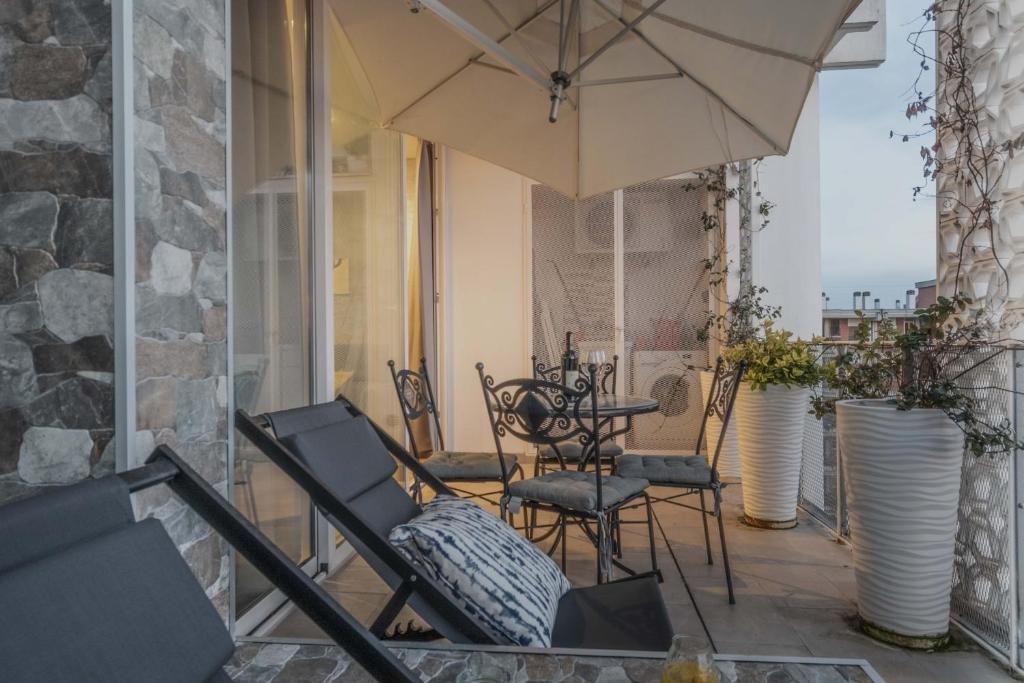 a patio with a table and chairs and an umbrella at Italian Experience-Florence Suite Apartment in Florence