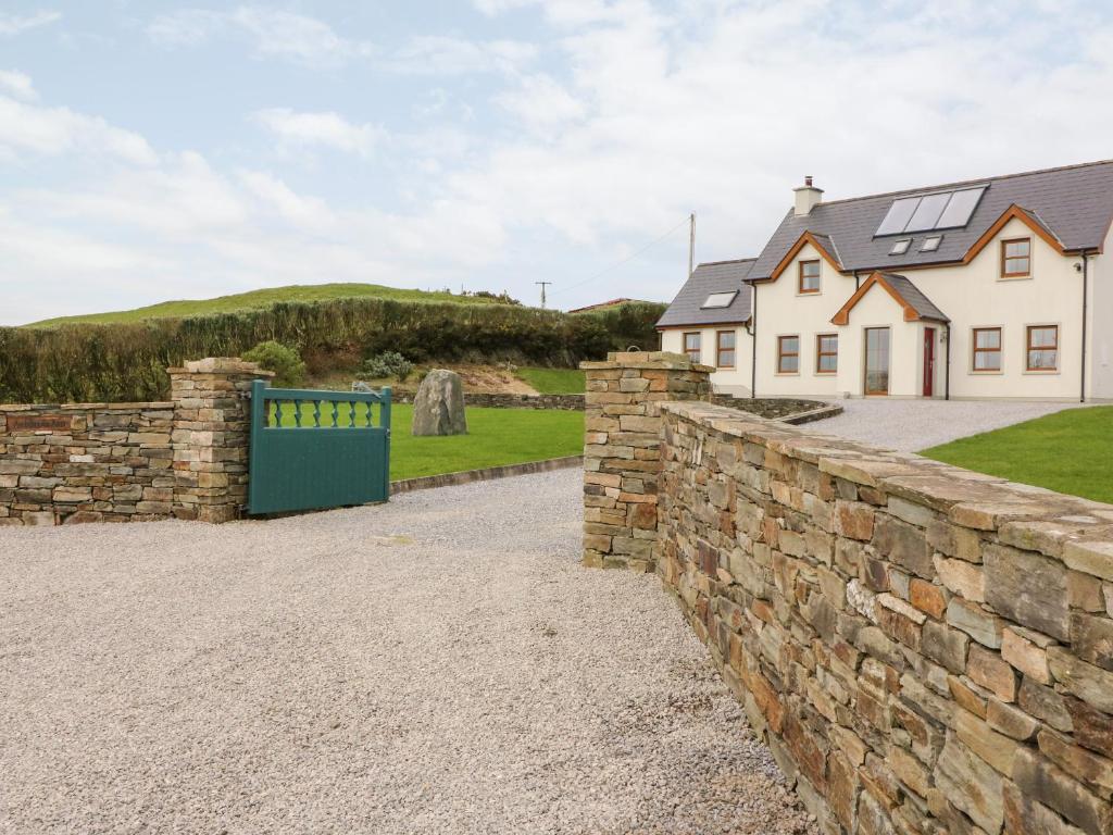 a stone retaining wall in front of a house at Ballycahane in Castletownshend
