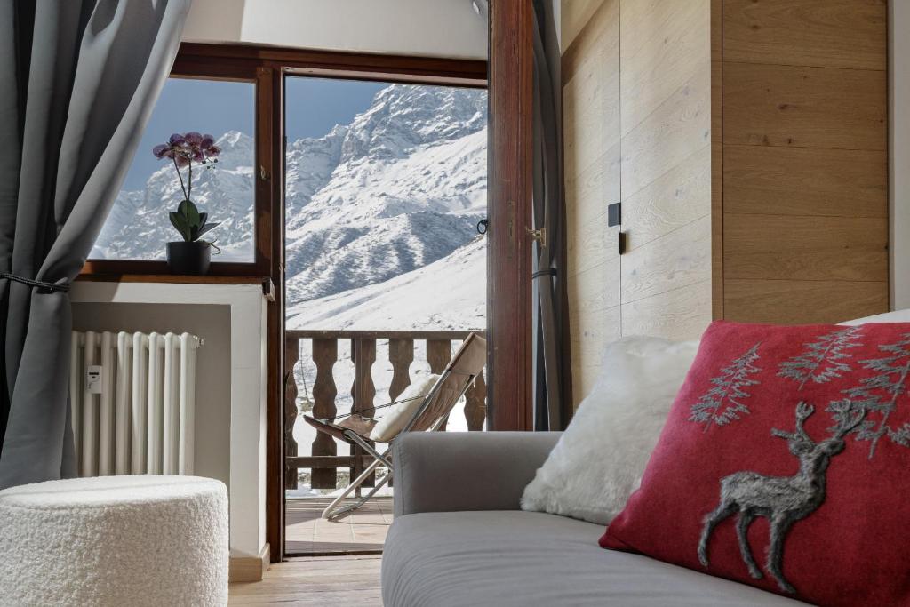 a living room with a couch and a view of a mountain at HelloChalet - Pandora Mountain View with jacuzzi, garage and ski storage in Breuil-Cervinia