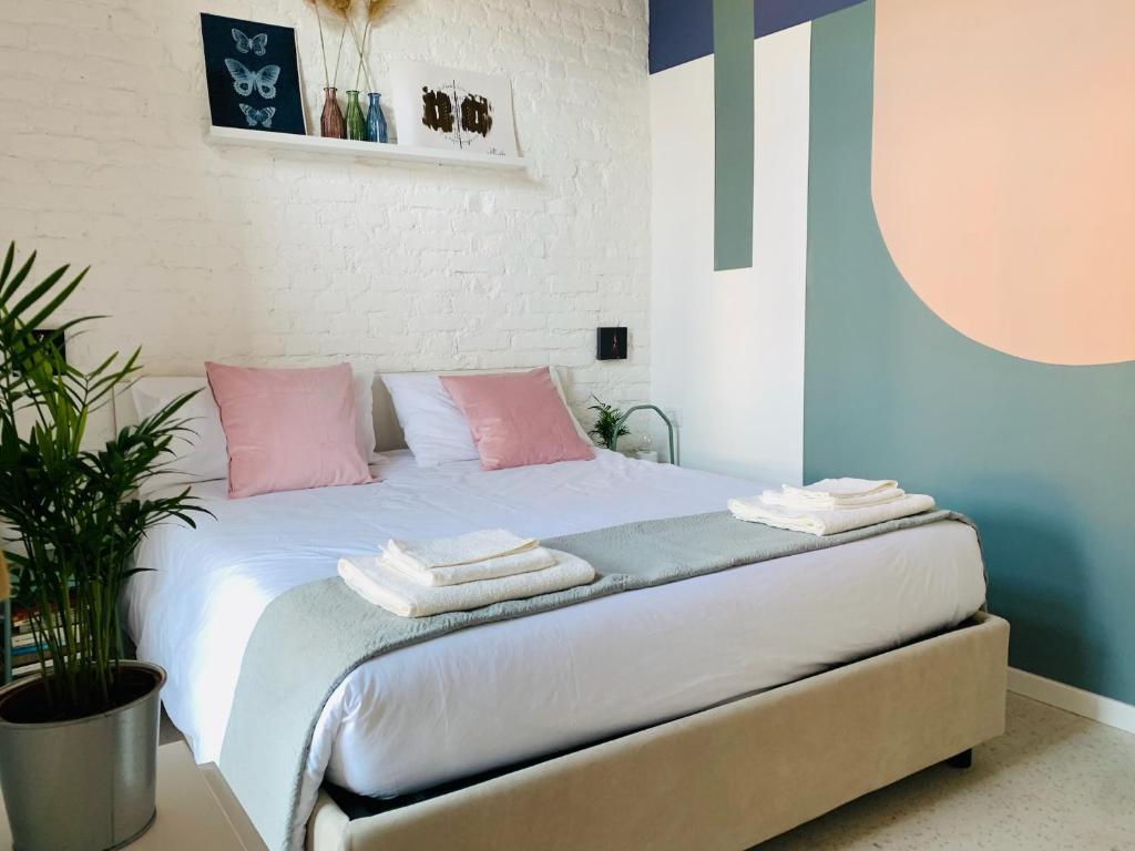 a bedroom with a bed with pink and blue walls at Stylish flat in Porta Romana-Fondazione Prada in Milan