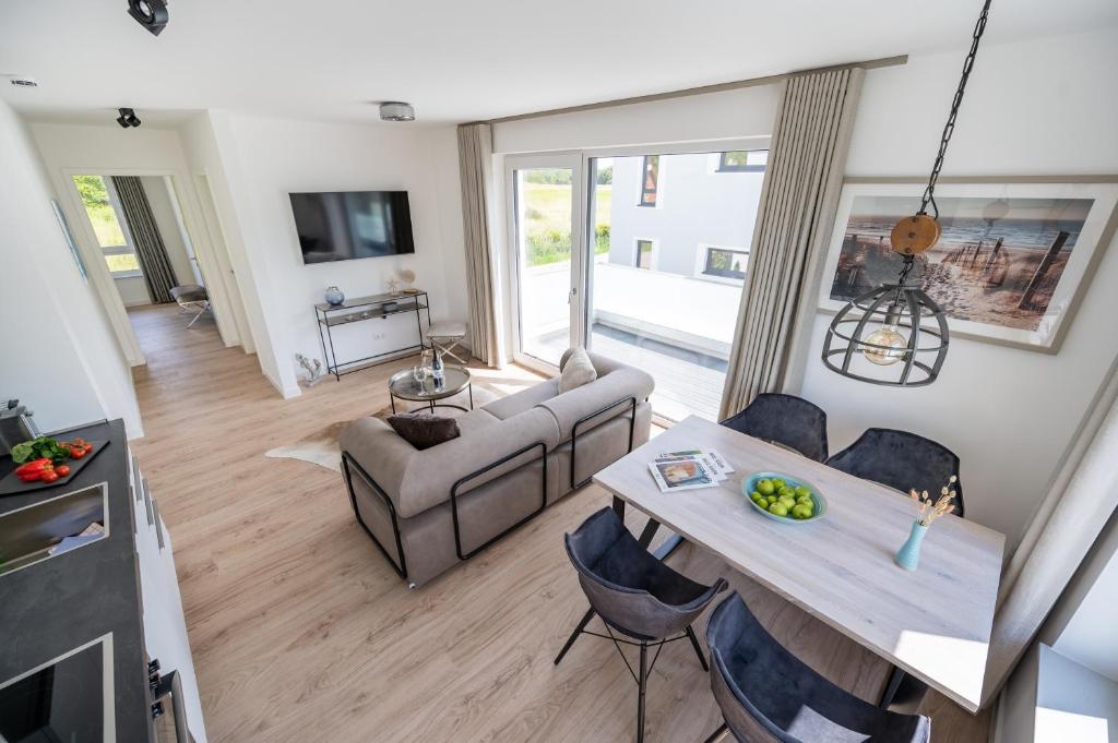 a living room with a table and a couch at Villa Zweite Heimat - Exklusive Penthouse No 4 in Lohme