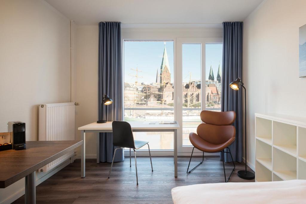 um quarto com uma secretária, uma cadeira e uma janela em TEERHOF58 em Bremen