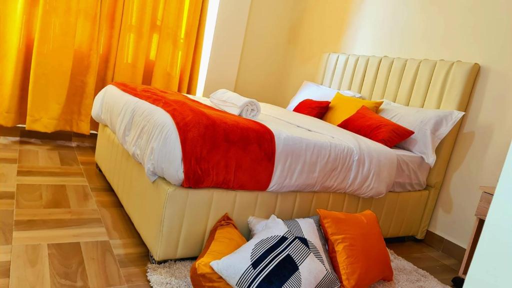 een bed met kleurrijke kussens in een kamer bij Studios,1,2 and 3bedrooms in Nakuru town with a lake view. in Nakuru