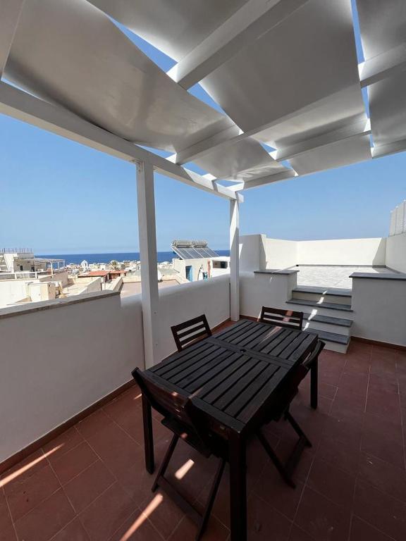 Ein Tisch und Stühle auf einem Balkon mit Blick auf das Meer in der Unterkunft Il Corallo in Marettimo
