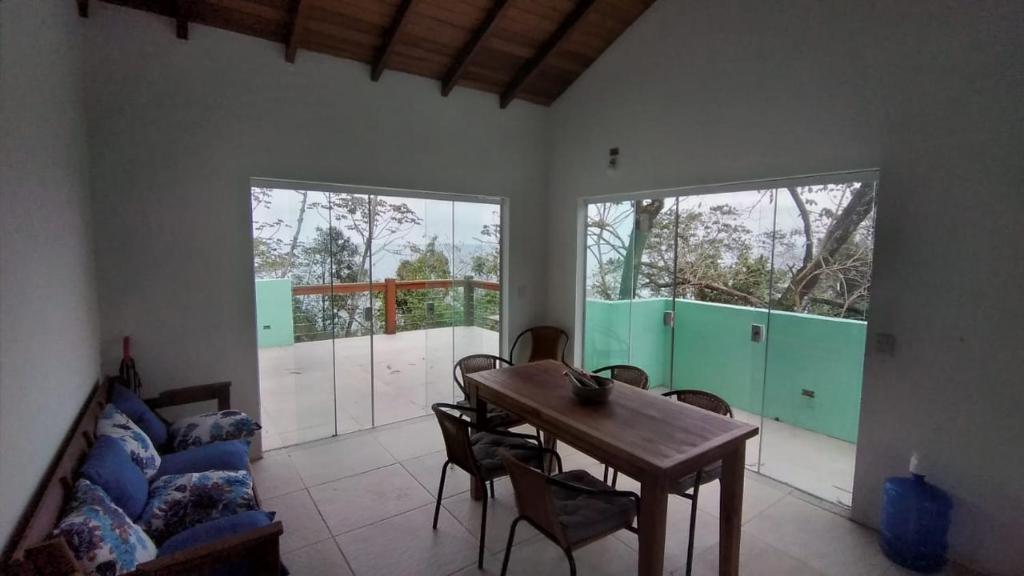 sala de estar con mesa de madera y sillas en Casa no Sul da Ilha, en Ilhabela