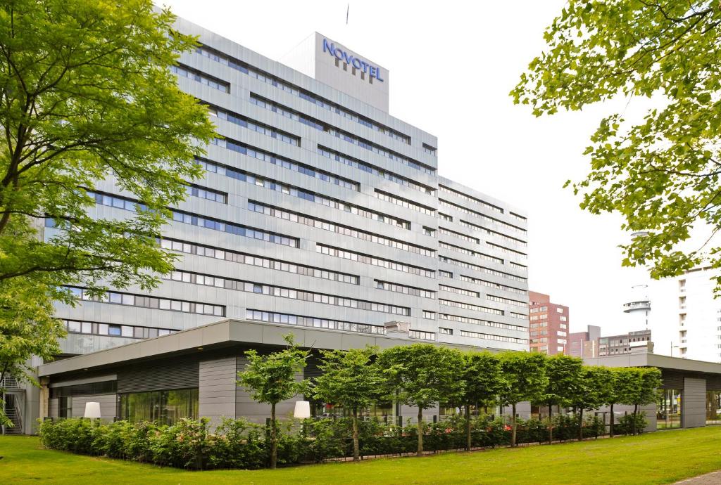 a large building with trees in front of it at Novotel Amsterdam City in Amsterdam