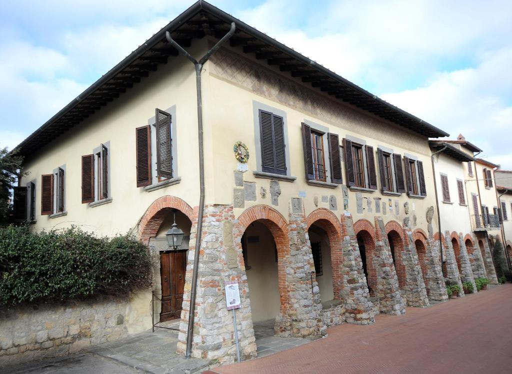 un antiguo edificio de piedra con persianas marrones. en Palazzo Tarlati - Hotel de Charme - Residenza d'Epoca, en Civitella in Val di Chiana