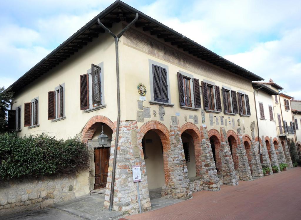 Palazzo Tarlati - Hotel de Charme - Residenza d'Epoca في سيفيتيلا إن فال دي تشيانا: مبنى حجري قديم عليه مصاريع بنية اللون