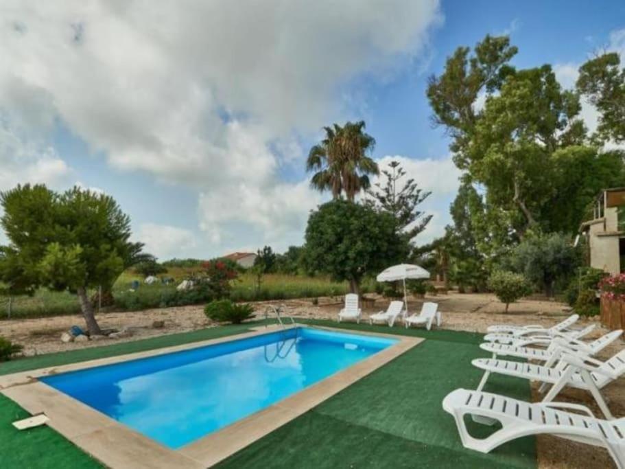 - une piscine avec des chaises longues blanches et un salon de natation dans l'établissement Casa Sorrapa con Piscina, à Deltebre