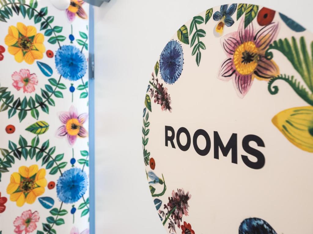 a book with flowers and a sign that reads rooms at Hostel Zahrada Mikulov in Mikulov