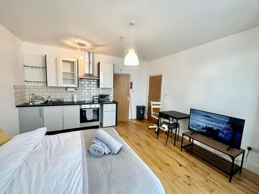 uma sala de estar com uma cama grande e uma cozinha em SE4, Self contained studio flat. em Londres