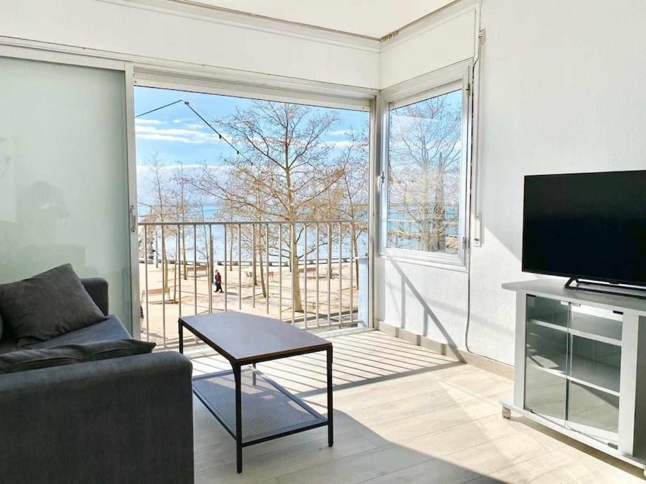 a living room with a couch and a large window at Estudio Frente al Mar en Roses con Vistas in Roses