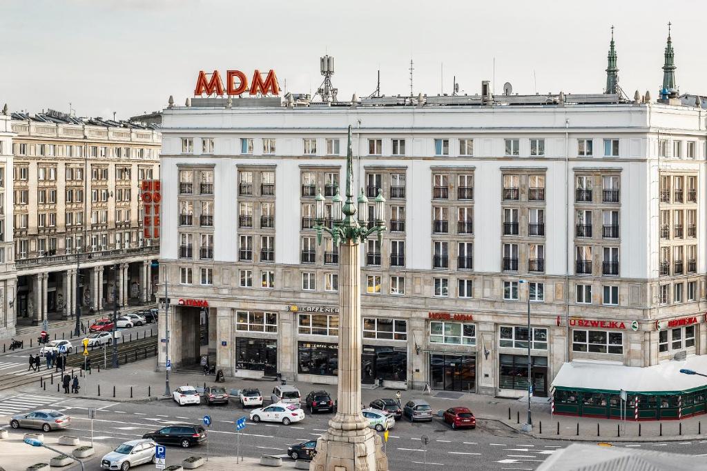 a large white building with a sign on top of it at Hotel MDM City Centre in Warsaw