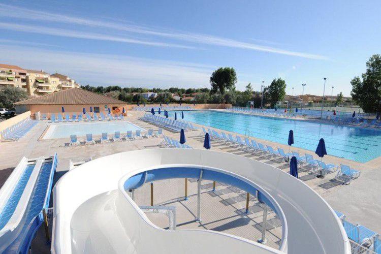 a large swimming pool with chairs and a large pool at Mobil home 8 personnes camping L'Elysée Vagues Océanes in Le Grau-du-Roi