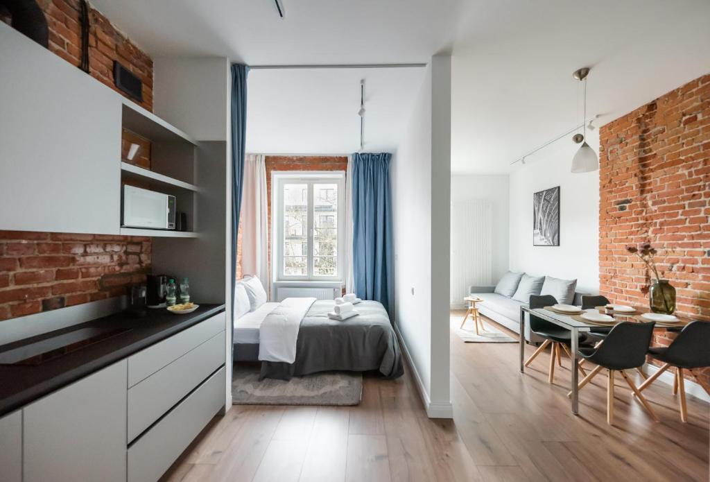 a living room with a bed and a dining room at East Warsaw Modern Apartment in Warsaw