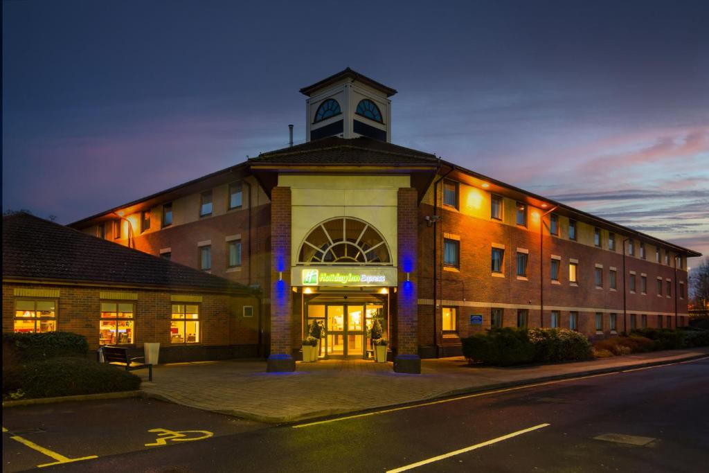 um edifício com uma torre de relógio em cima em Holiday Inn Express Warwick - Stratford-upon-Avon, an IHG Hotel em Warwick